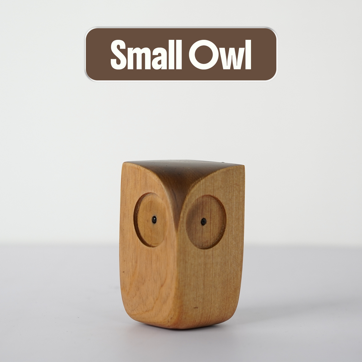 Small Wooden Owl Figurine on a plain background