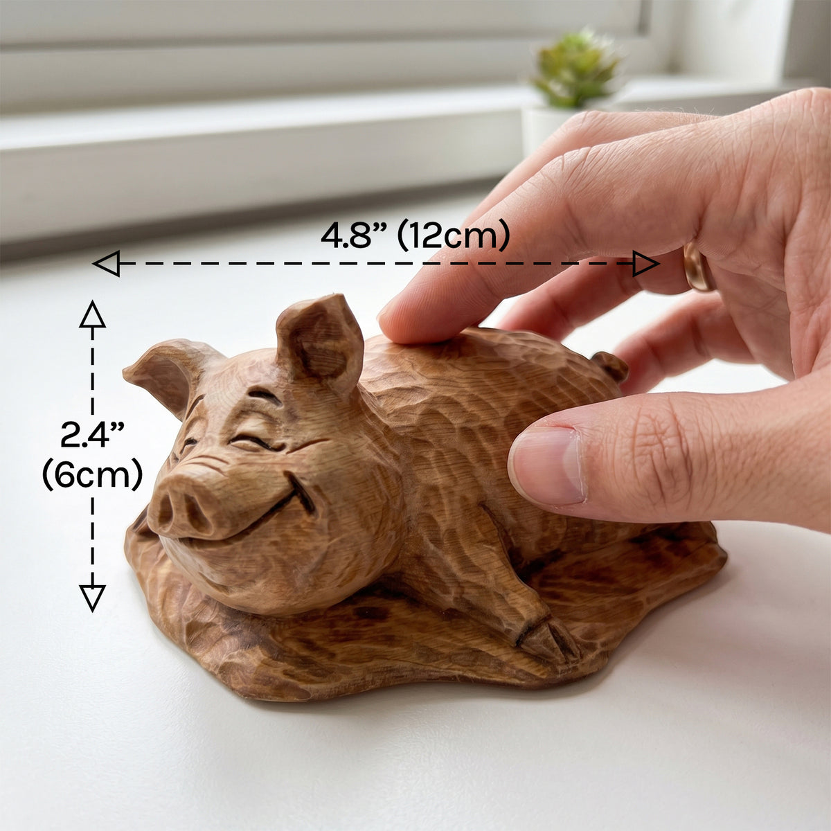 Wooden pig figurine on a table with dimensions labeled 4.8 inches by 2.4 inches