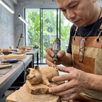 Person hand-carving the wooden pig figurine in a workshop