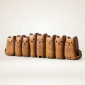 Row of hand-carved wooden cat figurines lined up on a white background