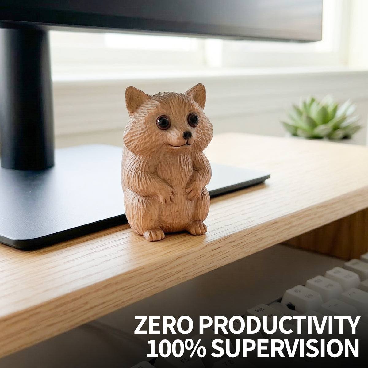 Wooden raccoon figurine on a desk with a monitor and succulent plant