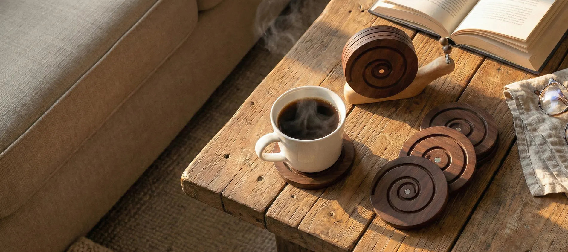 BeeRusty magnetic wooden snail coasters set displayed on a rustic wooden coffee table next to a steaming cup of coffee and an open book. Handcrafted farmhouse home decor